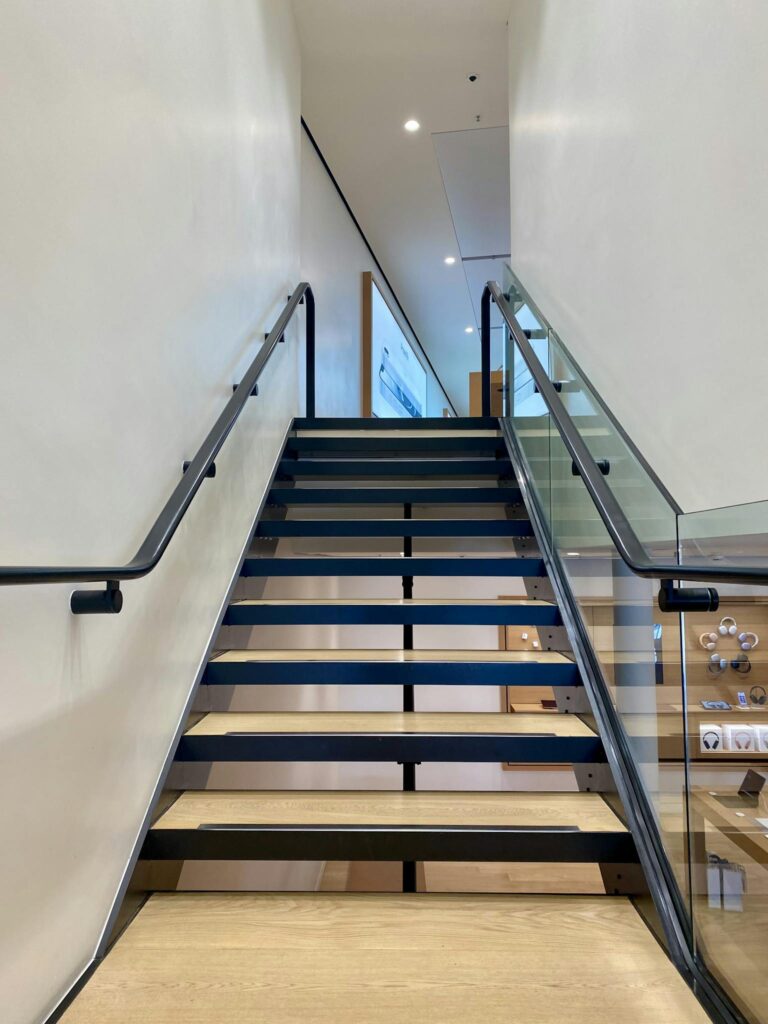 Elegant indoor staircase with glass railings and wooden steps, perfect for contemporary design.